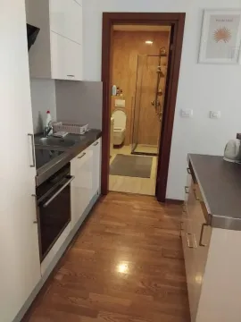 Manja kuhinja sa bijelim elementima i drvenim podom, sa pogledom na kupatilo. - image 10