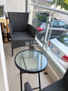 Enclosed balcony with seating furniture and a glass coffee table. - image 14