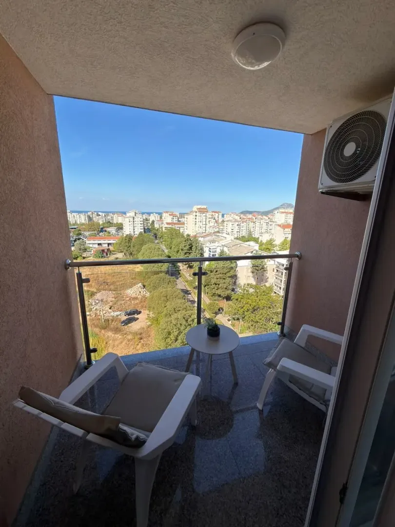 Furnished balcony with seating set and city view.