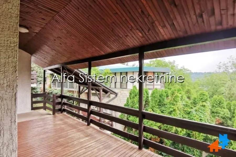 Large covered terrace with wooden cladding and a view of greenery.