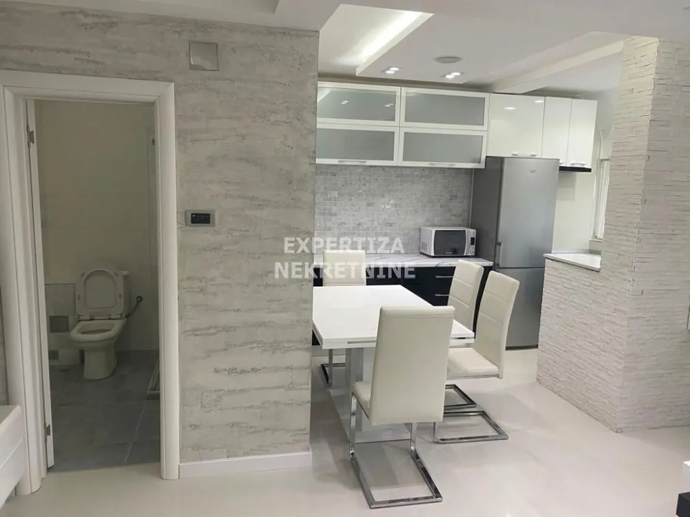 Dining area with kitchen and a view of the bathroom.