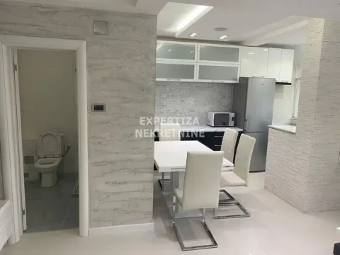 Dining area with kitchen and a view of the bathroom. - image 3