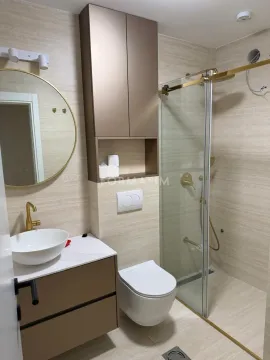 Modernly equipped bathroom with a shower cabin, washbasin, and gold details. - image 7