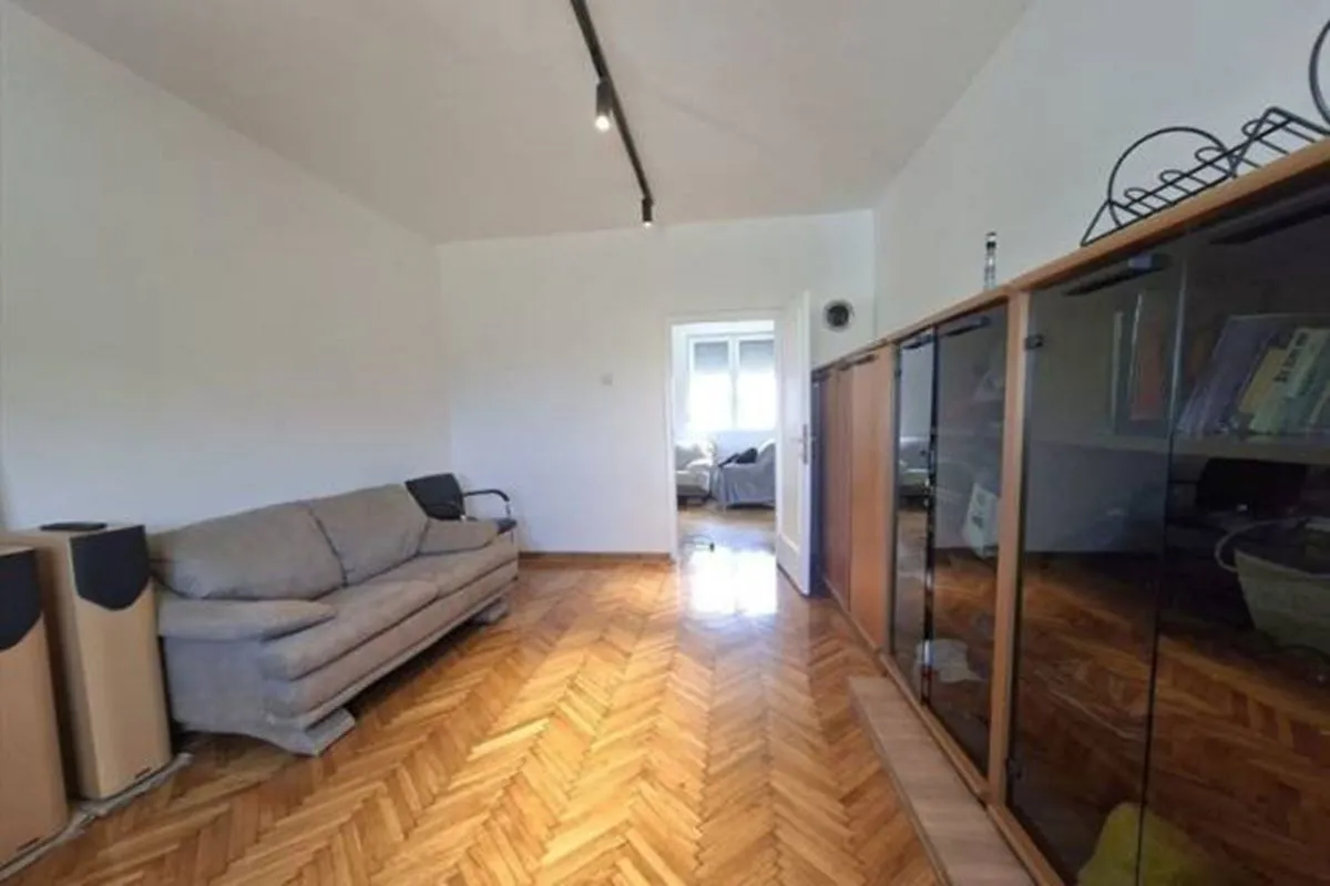 Living room with a seating sofa and wooden flooring.