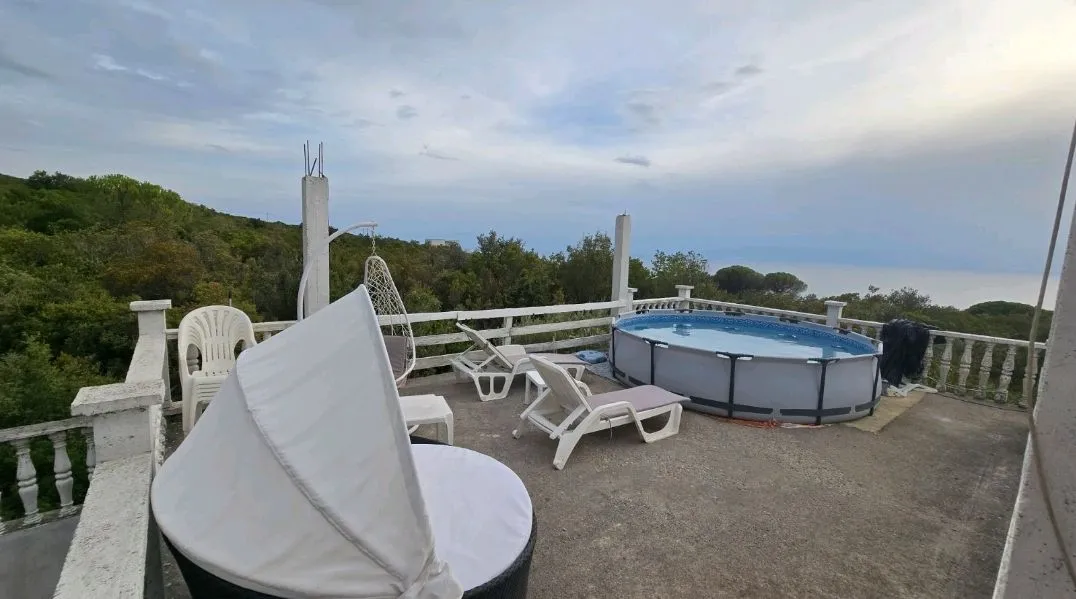 Spacious terrace with a pool, sun loungers, and nature views.
