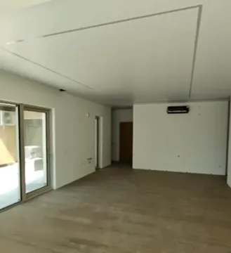 Prazna soba sa svijetlim zidovima, drvenim podom i izlazom na terasu. - image 4