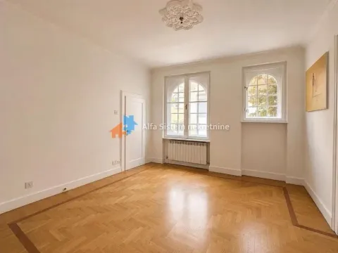 Empty room with wooden parquet flooring, white walls, and two windows. - image 2