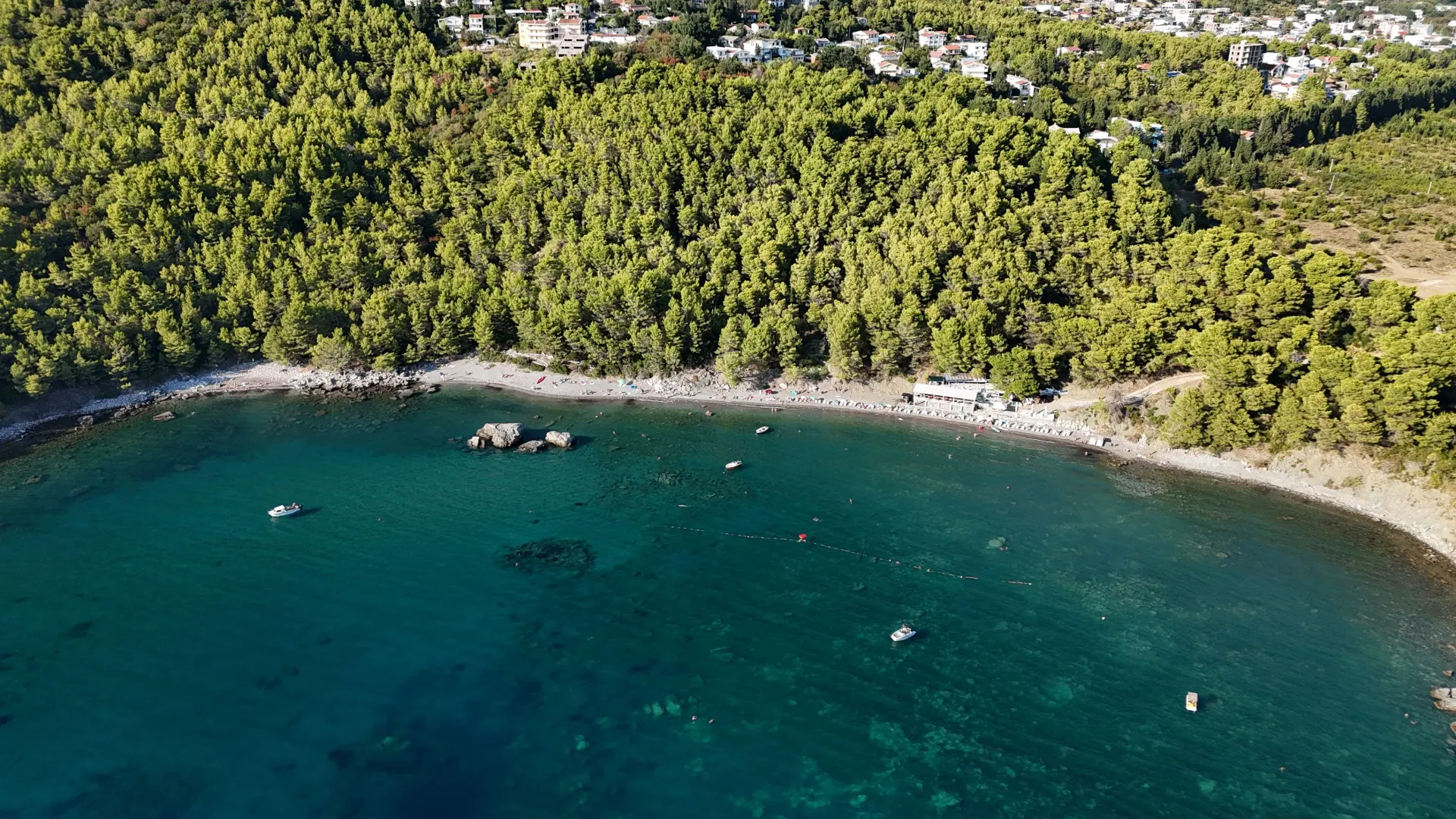 Pogled iz vazduha na uvalu, plažu i šumu.