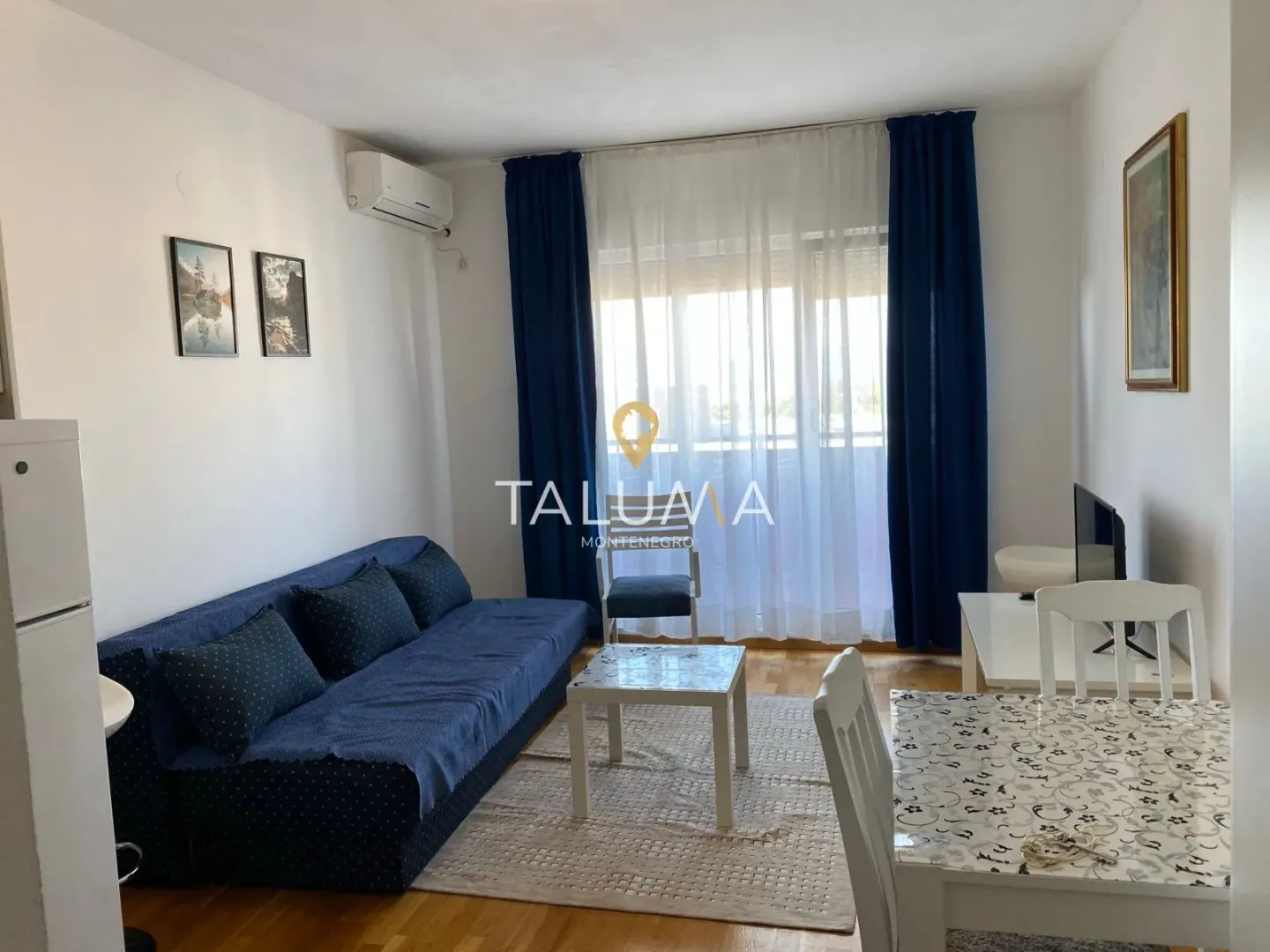 Living room with sofa, dining table and access to the terrace.