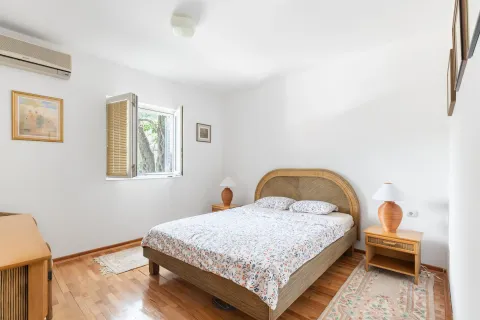 Svjetla spavaća soba sa bračnim krevetom, drvenim podom i prozorom. - image 4