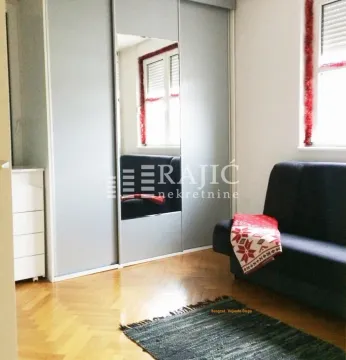 Smaller bedroom with a built-in wardrobe and a couch. - image 7