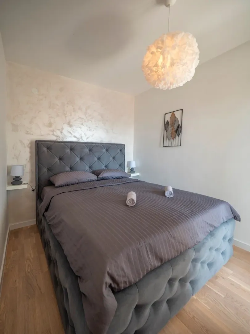 Bedroom with a large upholstered bed and decorative lighting.