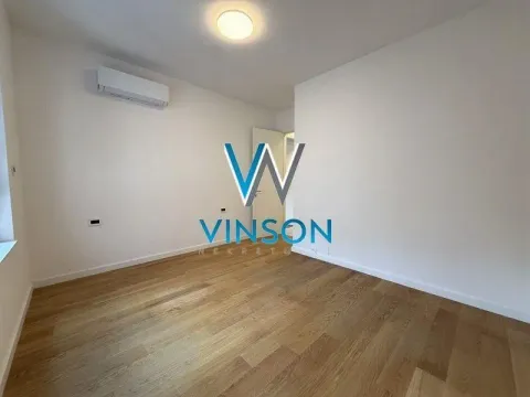 Empty room with white walls, wooden flooring, and an air conditioning unit. - image 8