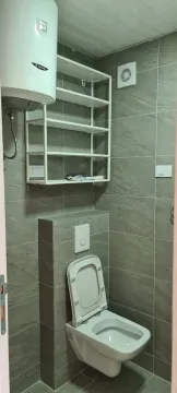 Mali toalet sa sivim pločicama, visećom šoljom i bojlerom. - image 13