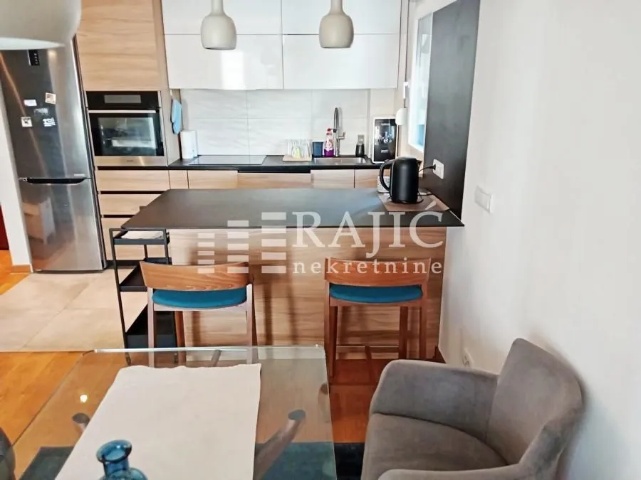 Modern kitchen with a bar counter and dining area.