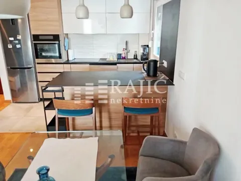 Modern kitchen with a bar counter and dining area. - image 5