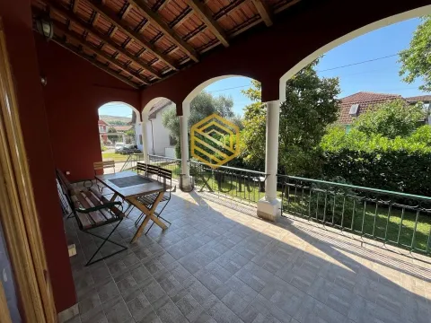 Covered terrace with a dining table and a view of the yard. - image 2