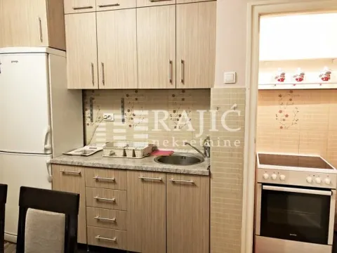 Small kitchen with wooden cabinets, refrigerator, and stove. - image 5