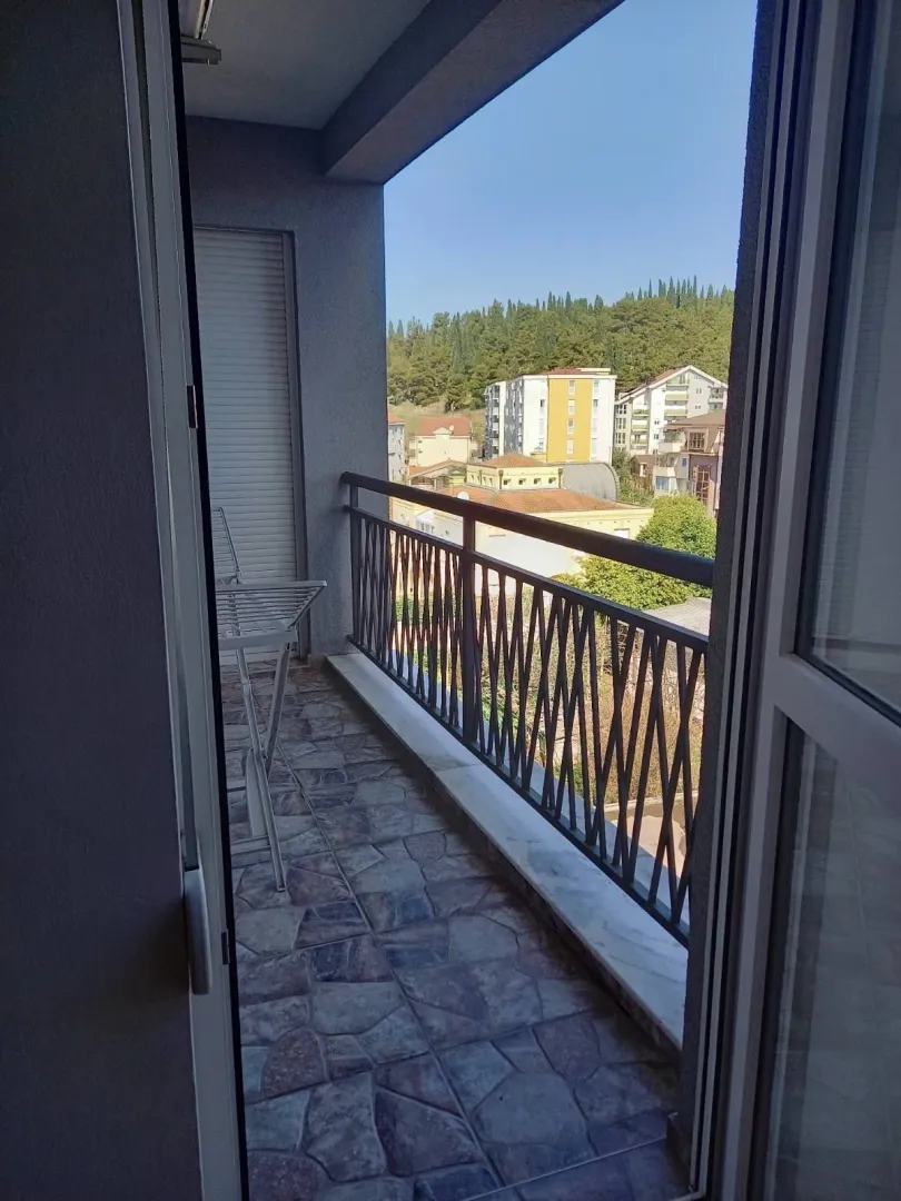 View from the apartment balcony of the surrounding buildings and greenery.
