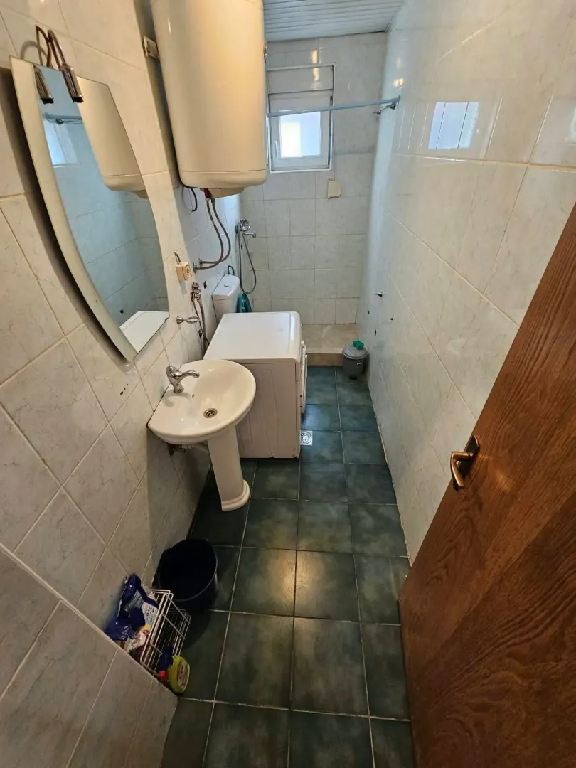 Manje kupatilo sa umivaonikom, veš mašinom i bojlerom.