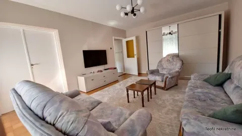 Living room with seating furniture, television, and a coffee table. - image 2