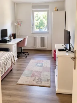 Furnished children's room with a bed, desk, and television. - image 10
