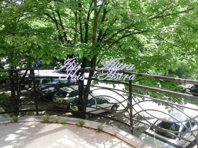 View from the balcony overlooking the parking lot and green trees.