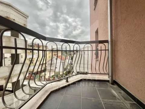Manji balkon sa metalnom ogradom i pogledom na naselje. - image 12