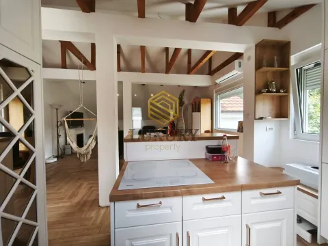 Modern kitchen with wooden countertops and a view of the living room. - image 11