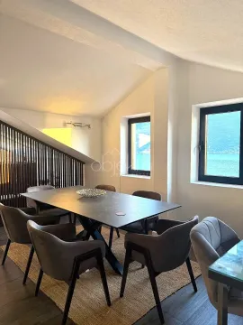 Dining area with a large table and chairs, featuring a sea view through the windows. - image 5