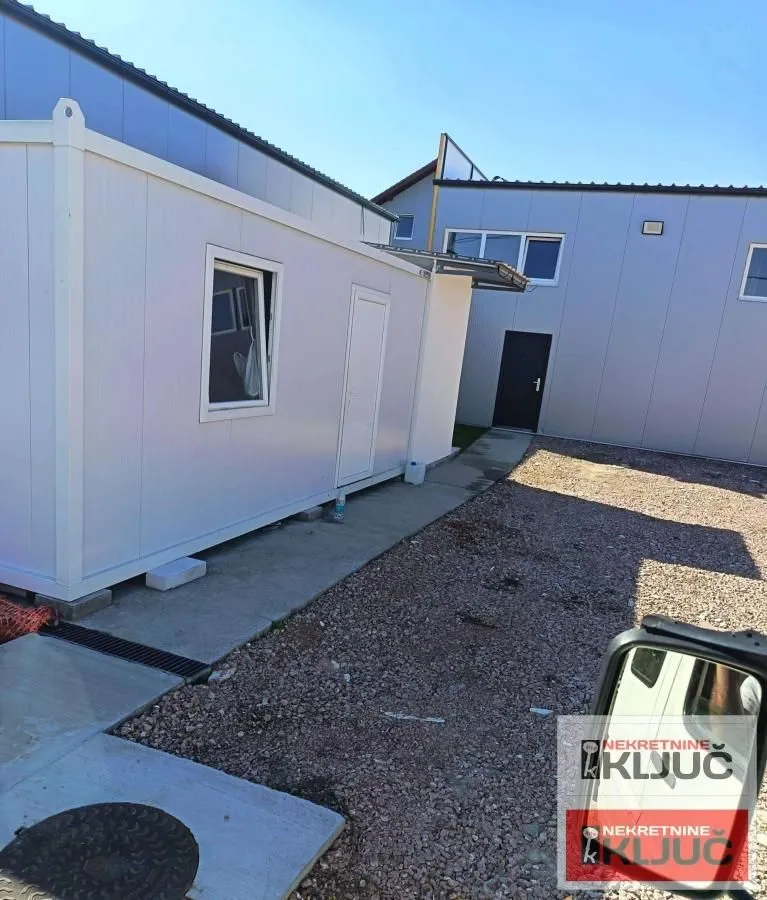 View of the exterior with a prefabricated structure and a paved courtyard.