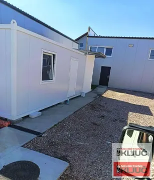 View of the exterior with a prefabricated structure and a paved courtyard. - image 5