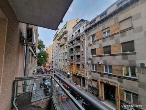 View from the balcony overlooking the city street and surrounding buildings. - image 6
