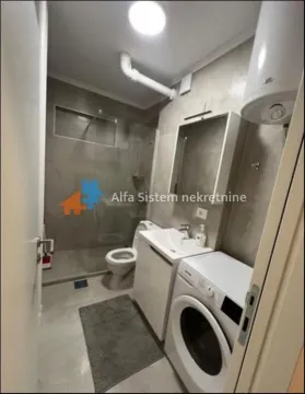 Modernly equipped bathroom with a walk-in shower and a washing machine. - image 10