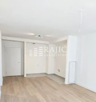 Empty room with wooden flooring and white walls. - image 3