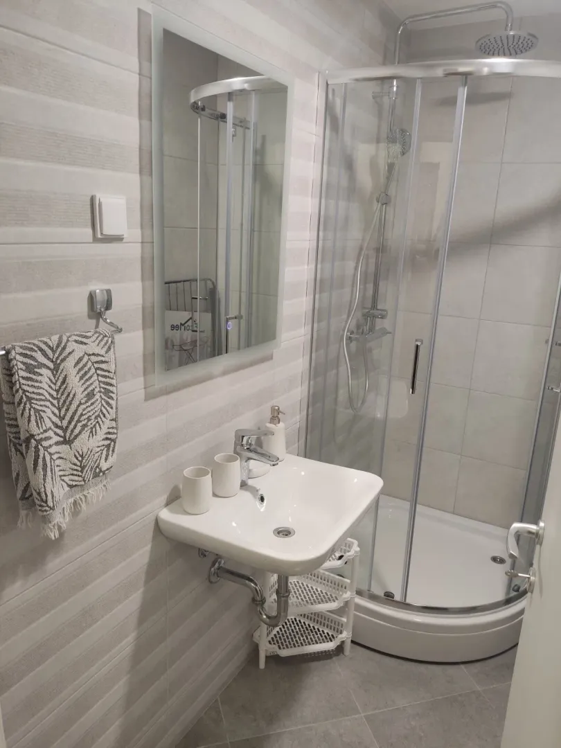 Bright and modern bathroom with a shower cabin and a mirror.