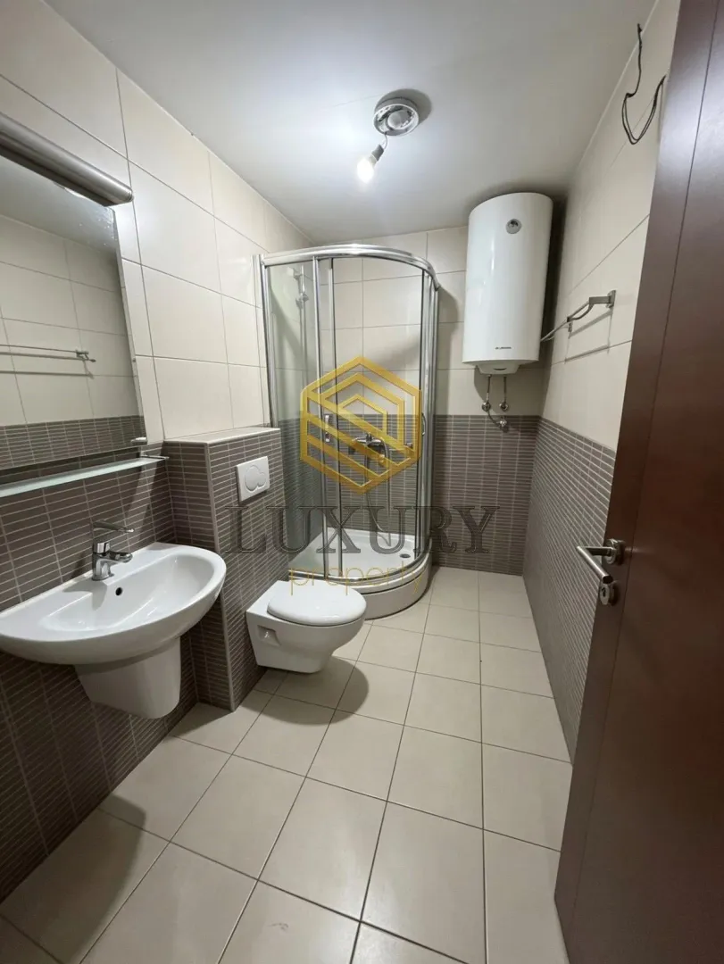Moderne kupatilo sa tuš kabinom, umivaonikom i wc šoljom.