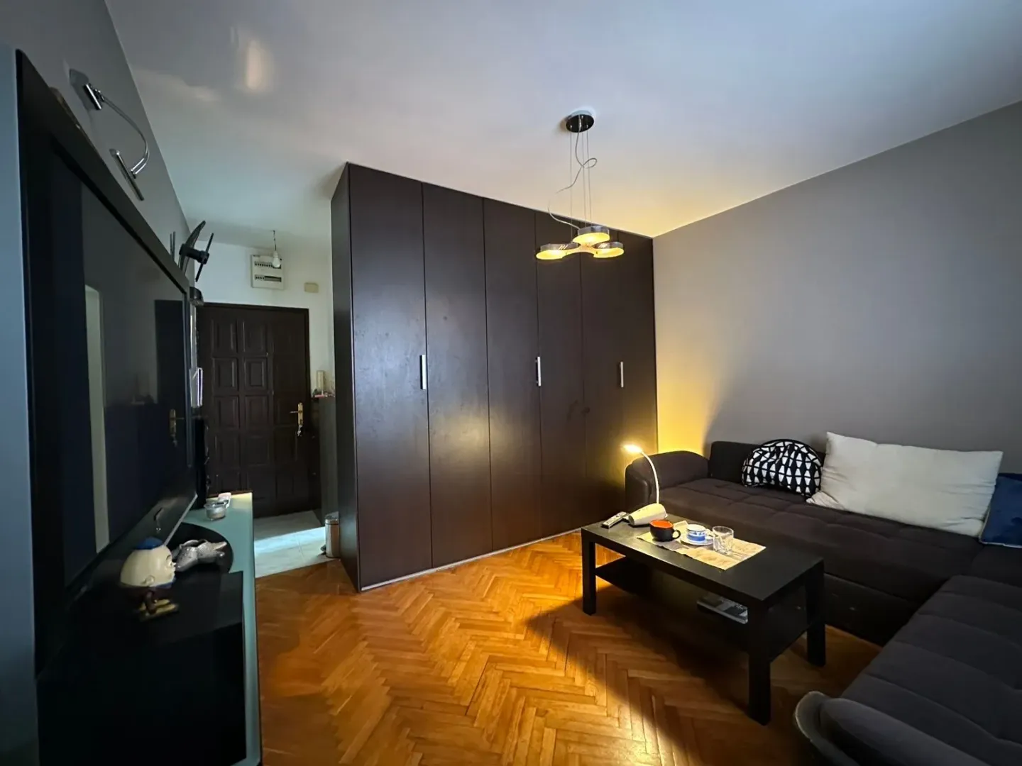 Living room with a sofa, large wardrobe and television.