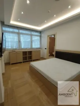 Bedroom with a double bed, wooden parquet flooring, and a dropped ceiling with lighting. - image 10