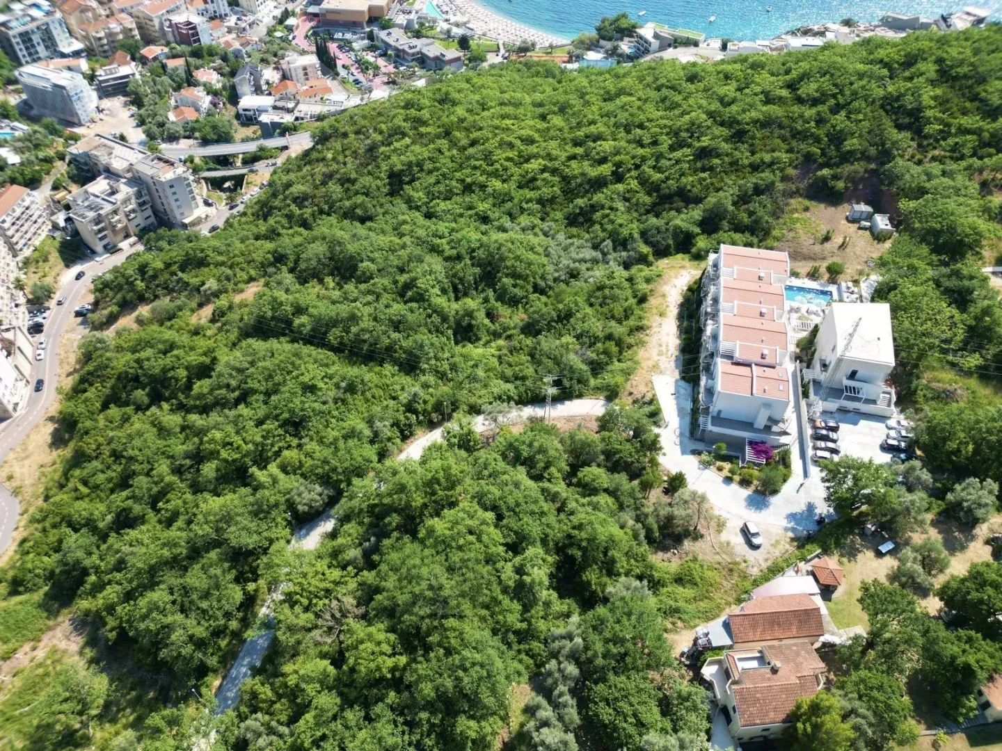 Pogled iz vazduha na objekte okružene zelenilom.