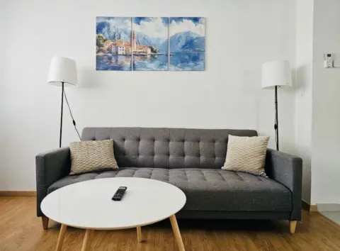 Dnevna soba sa sivim trosjedom, bijelim stočićem i dvije podne lampe. - image 2