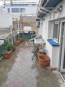 Dugačka terasa sa saksijama sa cvećem i stolom sa stolicama. - image 12