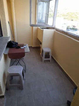 Uzak balkon sa malim stolom i dvije plastične stolice. - image 7