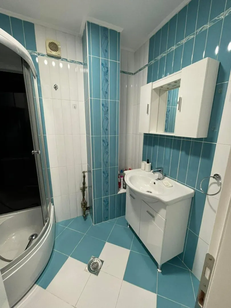 Small bathroom with a shower cabin and a white vanity with sink.