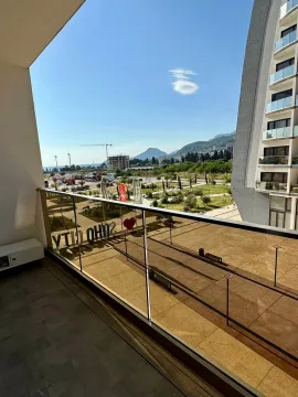 View from the balcony overlooking the landscaped area and surrounding buildings. - image 7