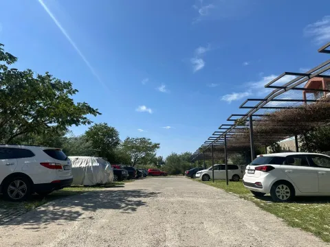 Otvoreni parking sa nadstrešnicama i parkiranim automobilima. - image 13