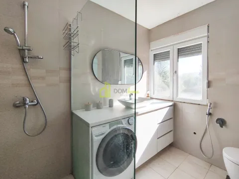 Modern bathroom equipped with a walk-in shower, washbasin, and washing machine. - image 18