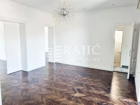 Bright empty room with parquet flooring and a decorative chandelier. - image 9