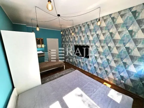 Furnished bedroom with a bed and patterned wallpaper. - image 12