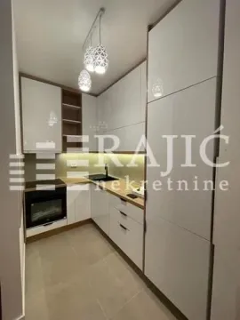 Modern kitchen with white units and built-in appliances. - image 10